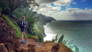 woman walking along kalalau trail in kauai